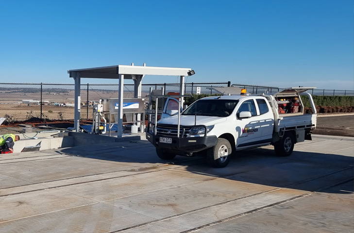Permanent vehicle wash bay with concrete washdown area and treatment equipment
